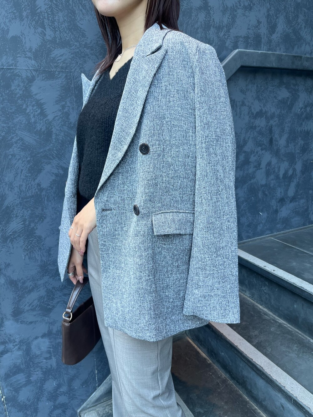 ブラック系のニット/セーター、ブラウン系のハンドバッグ、ブラック系のブーツを着用したレディースの冬コーディネートの6枚目の写真