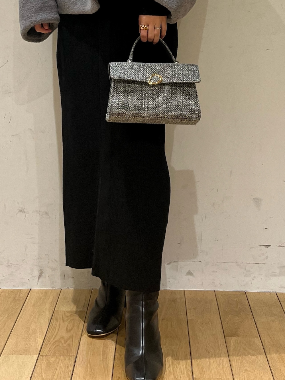 ブラック系のブーツ、グレー系のブルゾン、ブラック系のワンピースを着用したレディースの冬コーディネートの7枚目の写真