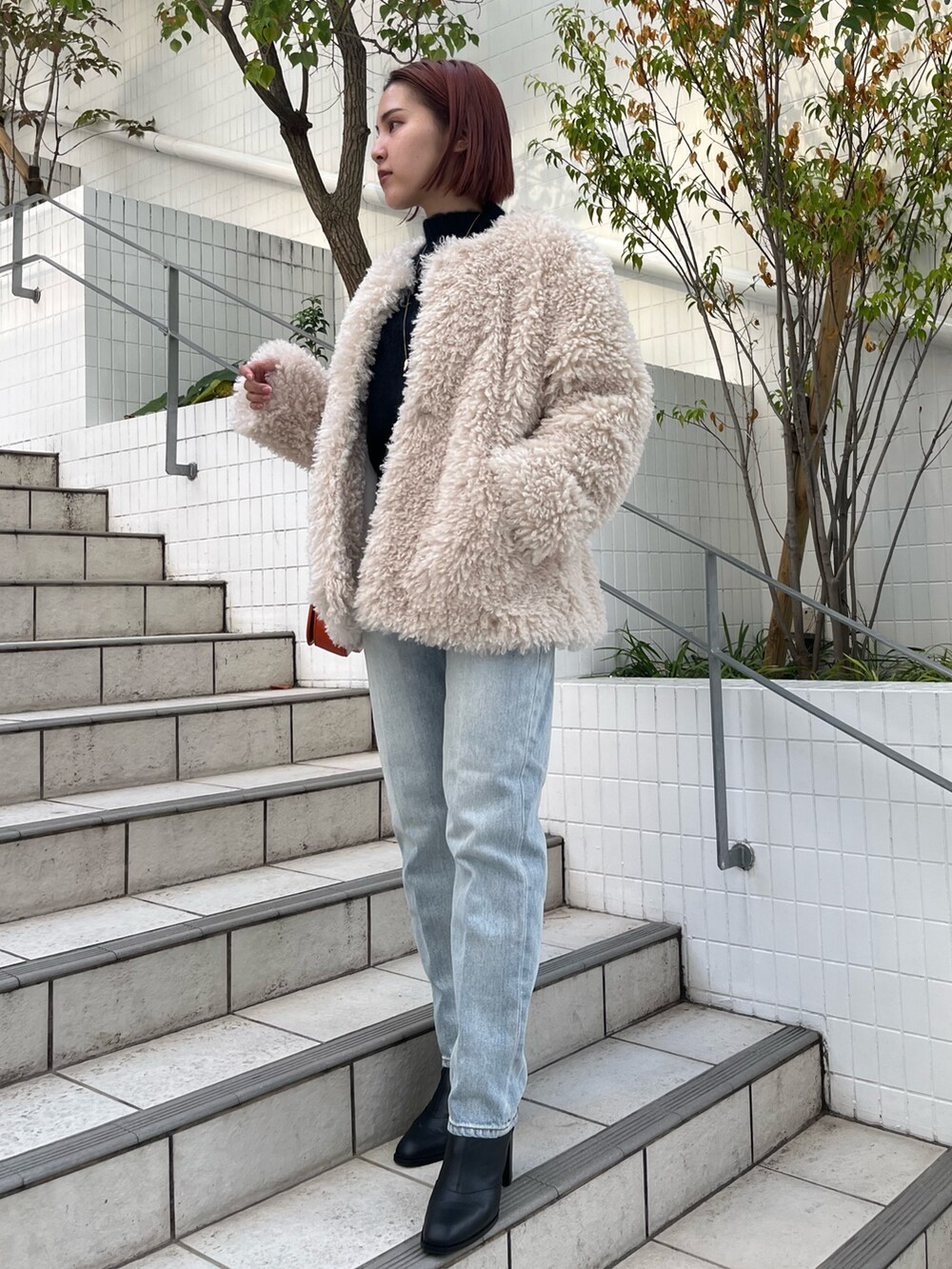 ブルー系のニット/セーター、ホワイト系のその他アウター、ブルー系のデニムパンツを着用したレディースの秋コーディネートの5枚目の写真