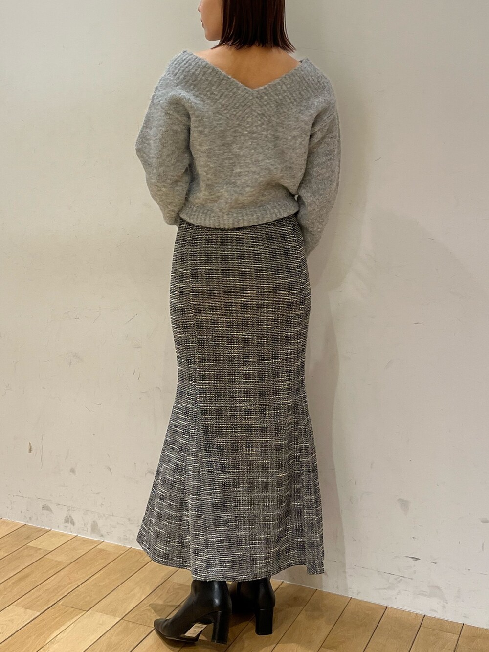 グレー系のニット/セーター、ブラック系のスカートを着用したレディースの冬コーディネートの3枚目の写真