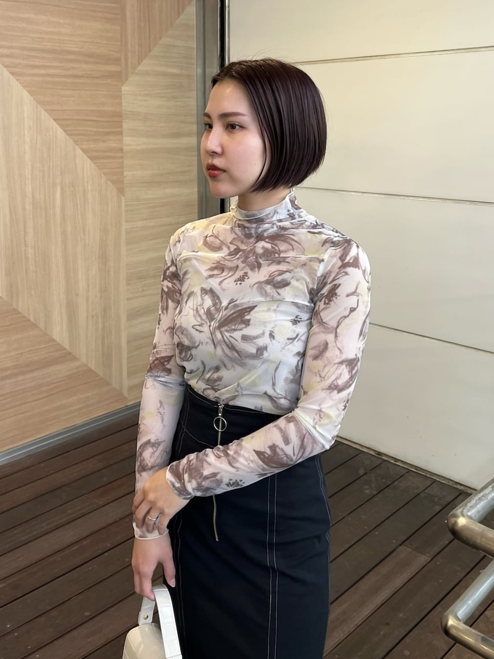 ブラック系のスカート、ブラック系のパンプス、イエロー系のTシャツ/カットソーを着用したレディースの春コーディネートの4枚目の写真