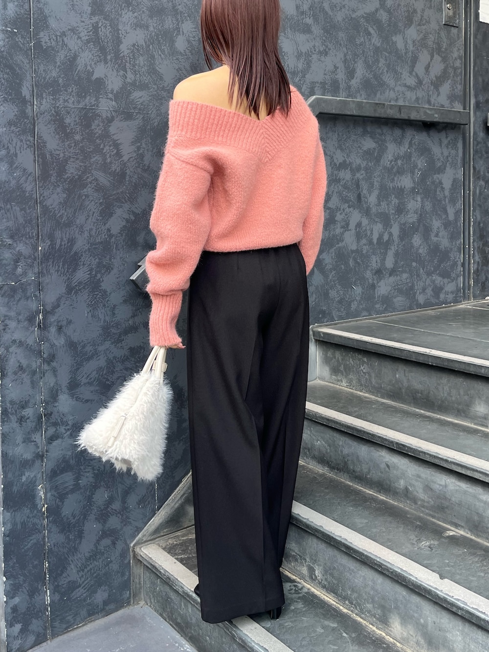 ブラック系のブーツ、ピンク系のニット/セーター、ホワイト系のボストンバッグを着用したレディースの秋コーディネートの3枚目の写真