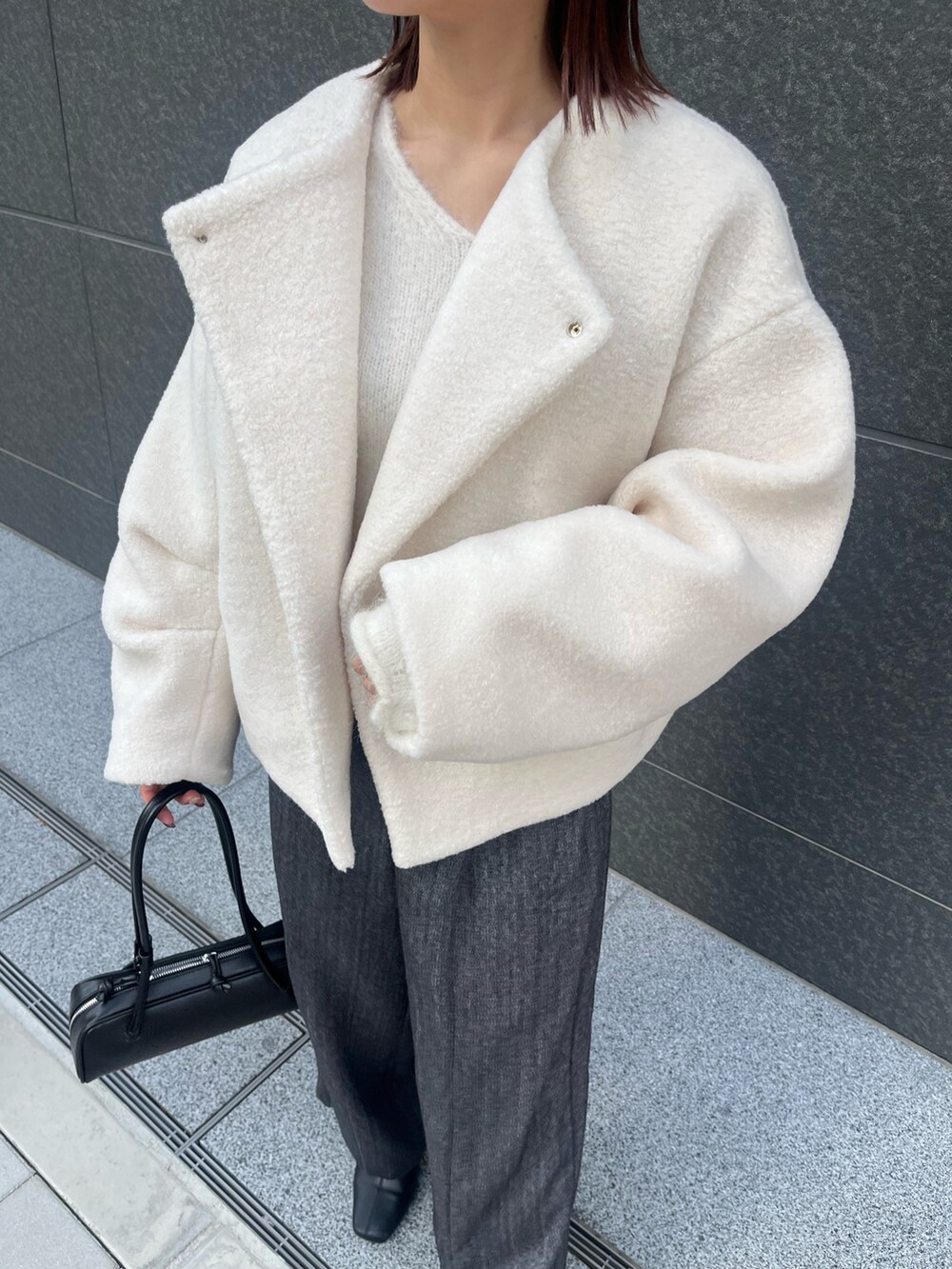 グレー系のその他パンツ、ホワイト系のニット/セーター、ホワイト系のブルゾンを着用したレディースの冬コーディネートの7枚目の写真