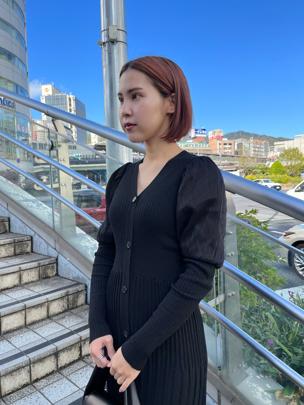 ブラック系のワンピース、ブラック系のハンドバッグ、ベージュ系のブーツを着用したレディースの秋コーディネートの4枚目の写真