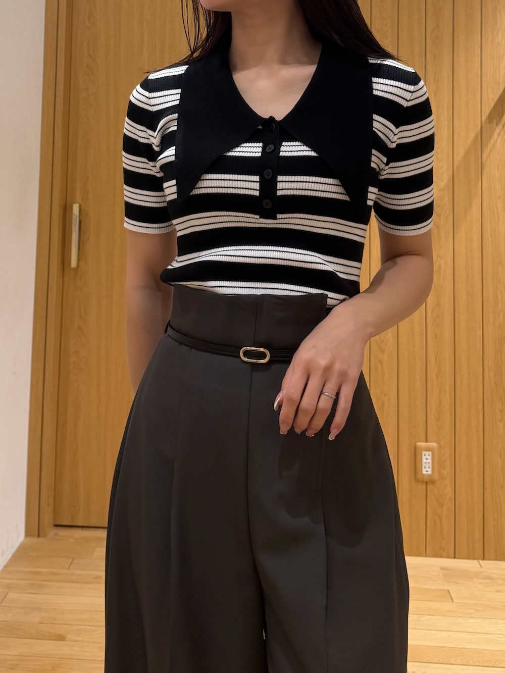 グレー系のその他パンツ、ブラック系のニット/セーター、ブラック系のパンプスを着用したレディースの春コーディネートの4枚目の写真