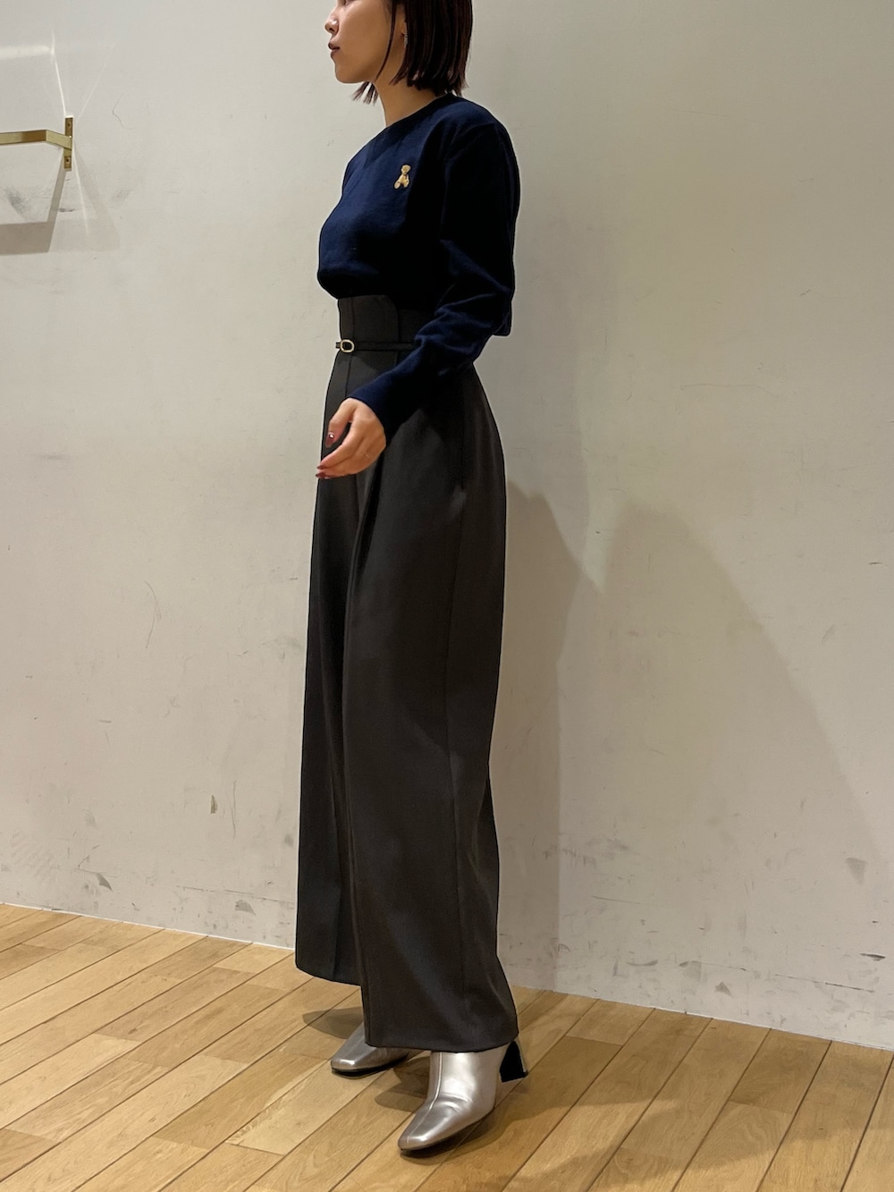 グレー系のその他パンツ、シルバー系のブーツ、ブルー系のニット/セーターを着用したレディースの秋コーディネートの2枚目の写真