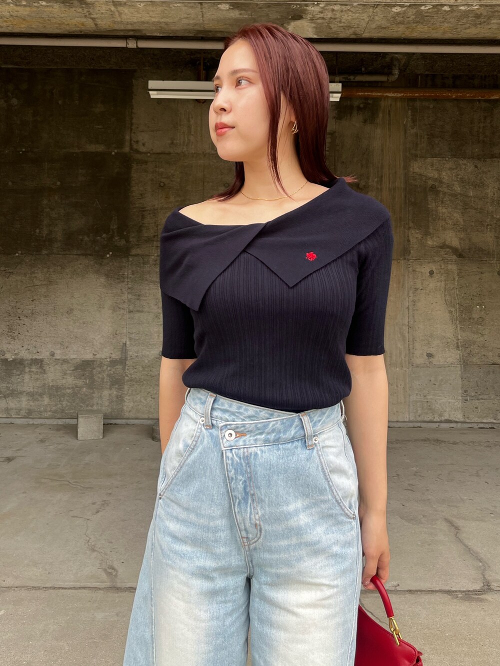 ブルー系のデニムパンツ、ブルー系のニット/セーター、レッド系のハンドバッグを着用したレディースの春コーディネートの4枚目の写真