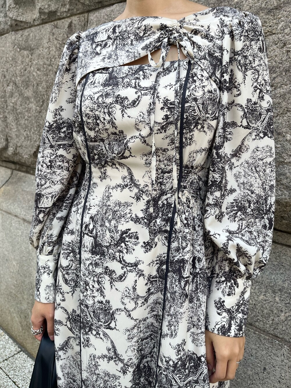 ホワイト系のワンピース、ブラック系のハンドバッグ、ブラック系のブーツを着用したレディースの冬コーディネートの5枚目の写真