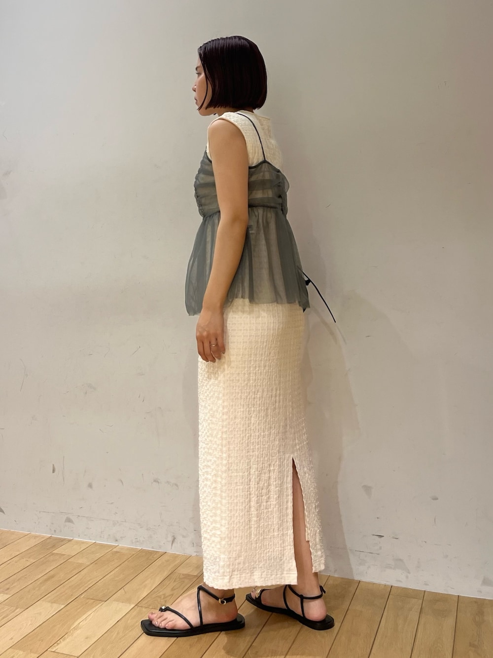 ホワイト系のワンピース、ブラック系のショルダーバッグ、ブラック系のサンダルを着用したレディースの夏コーディネートの2枚目の写真