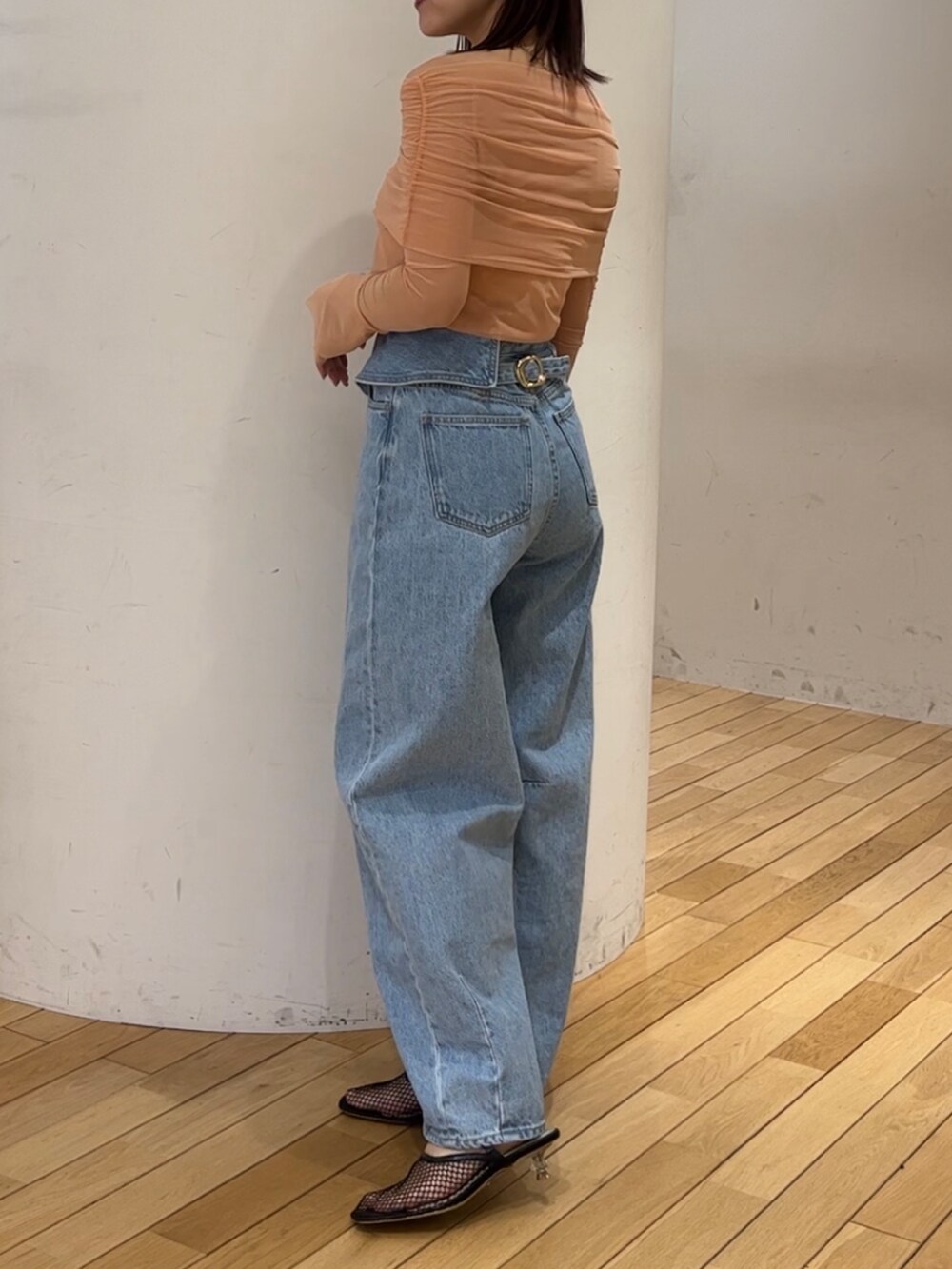 ブラック系のショルダーバッグ、ブラック系のサンダル、ブルー系のデニムパンツを着用したレディースの春コーディネートの2枚目の写真