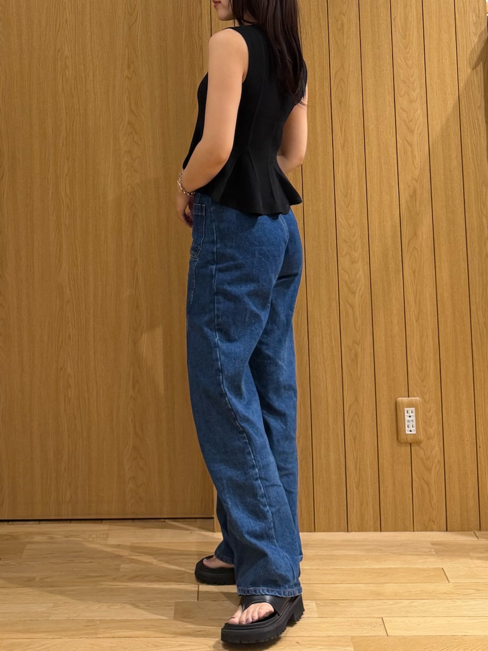 ブルー系のデニムパンツ、ブラック系のニット/セーターを着用したレディースの夏コーディネートの2枚目の写真