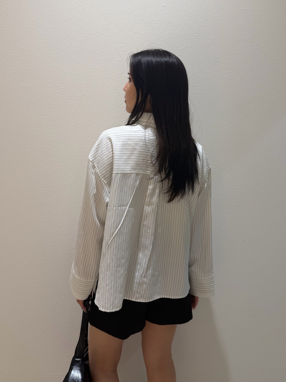 ブラック系のその他パンツ、ホワイト系のシャツ/ブラウス、ブラック系のブーツを着用したレディースの秋コーディネートの5枚目の写真