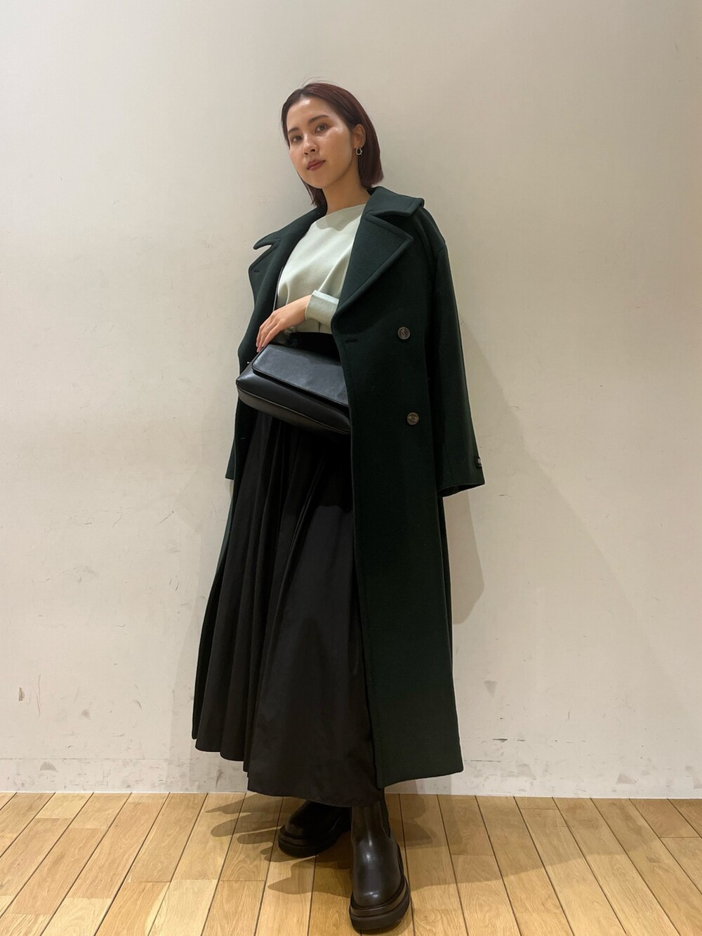 ブラック系のブーツ、グリーン系のニット/セーター、グリーン系のステンカラーコートを着用したレディースの冬コーディネートの3枚目の写真
