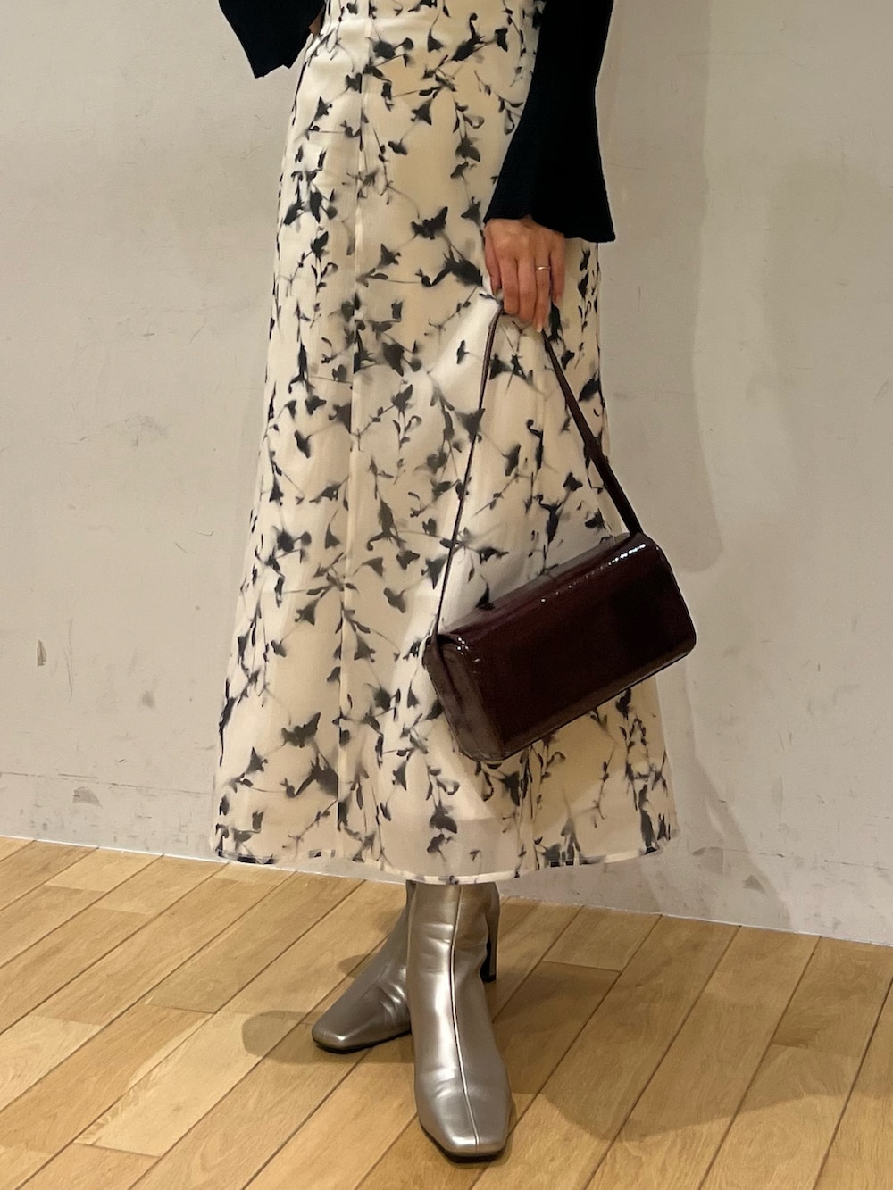 レッド系のショルダーバッグ、ホワイト系のスカート、シルバー系のブーツを着用したレディースの秋コーディネートの5枚目の写真