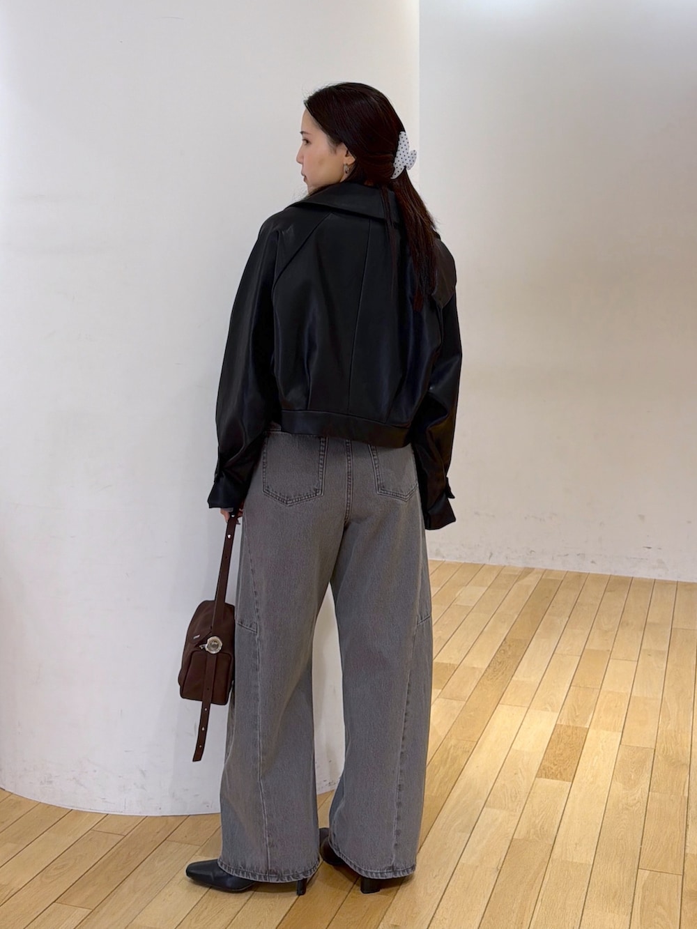 グレー系のデニムパンツ、ブルー系のTシャツ/カットソー、ブラック系のブルゾンを着用したレディースの秋コーディネートの3枚目の写真