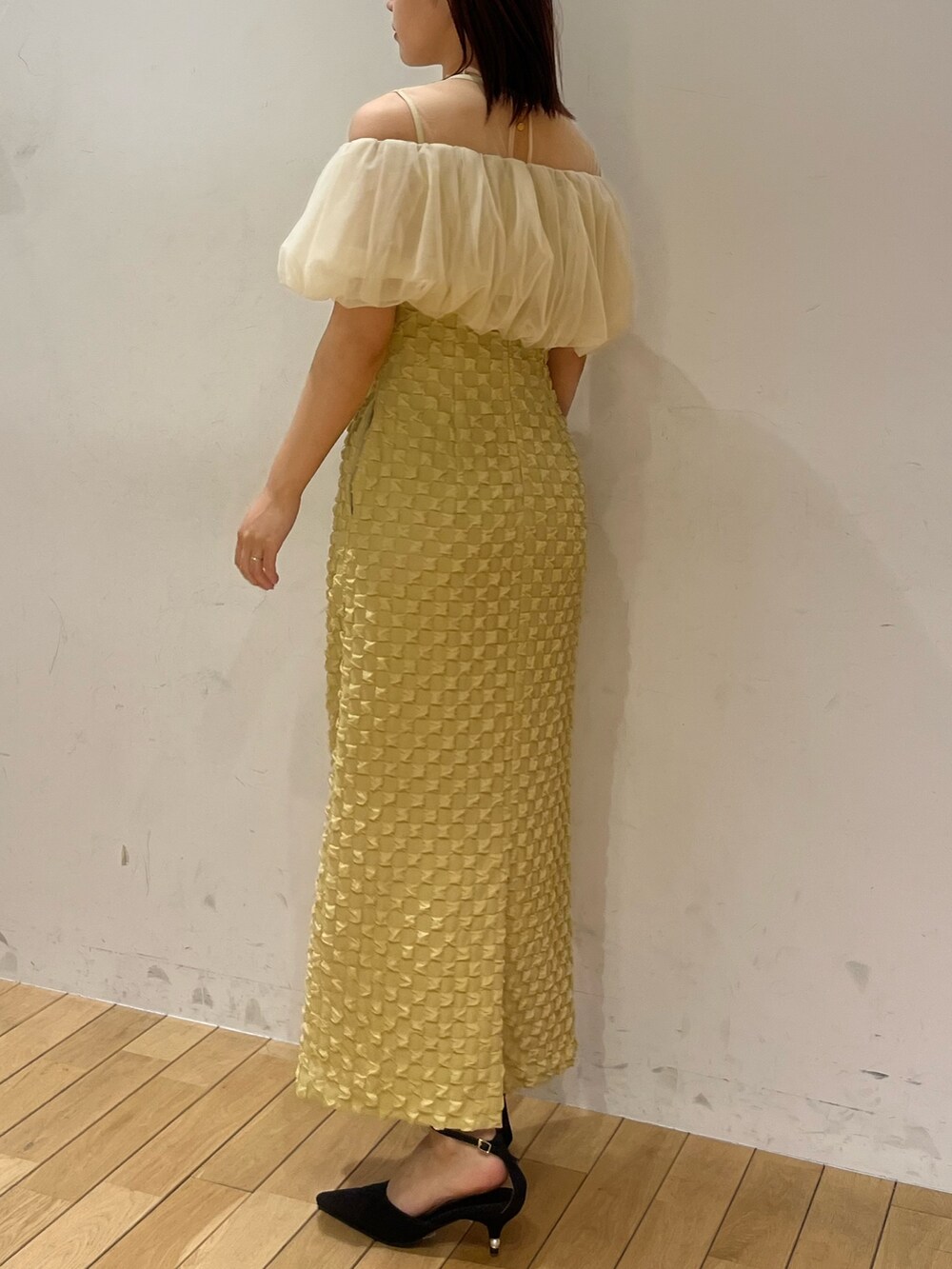 イエロー系のドレス、ブラック系のパンプスを着用したレディースの春コーディネートの3枚目の写真