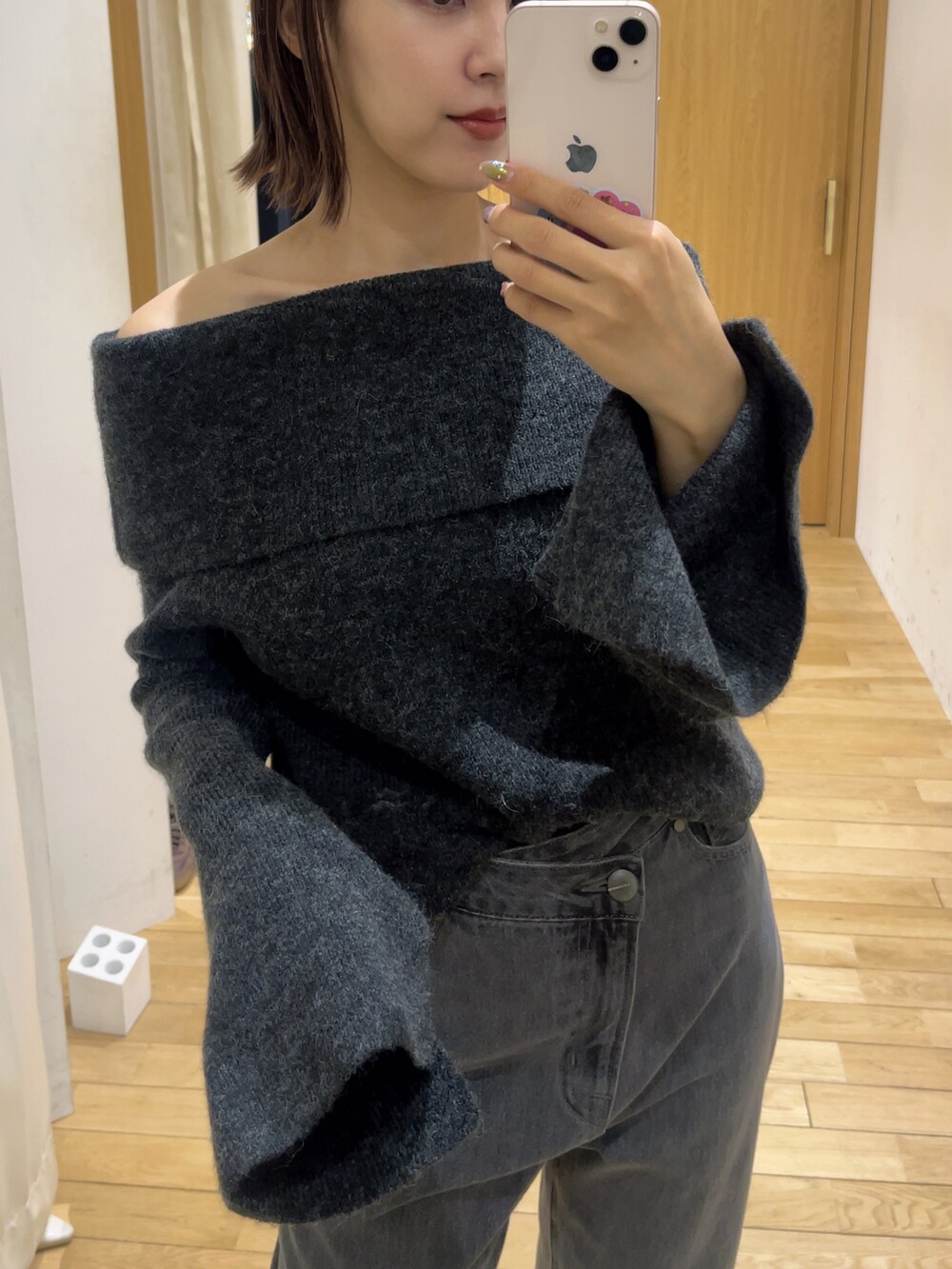 ブラック系のデニムパンツ、グレー系のニット/セーター、ブラック系のショルダーバッグを着用したレディースの秋コーディネートの6枚目の写真