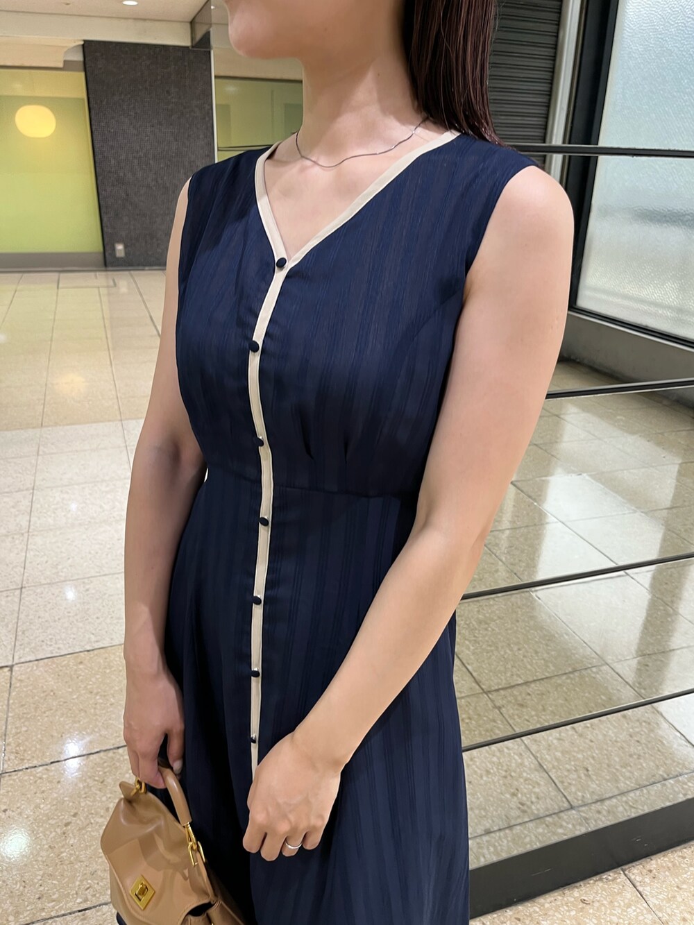 ブルー系のワンピース、ブラウン系のハンドバッグ、ブラック系のサンダルを着用したレディースの夏コーディネートの8枚目の写真
