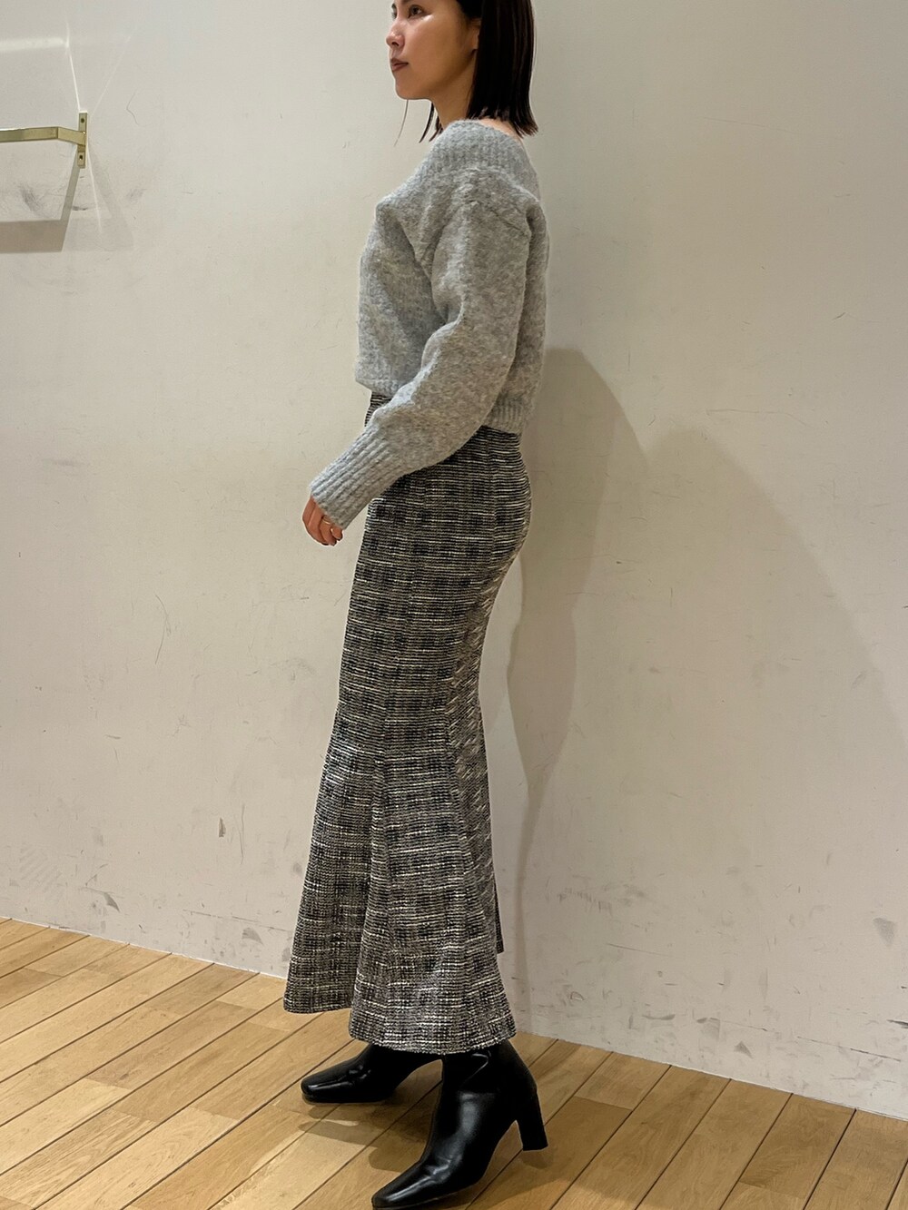 グレー系のニット/セーター、ブラック系のスカートを着用したレディースの冬コーディネートの2枚目の写真