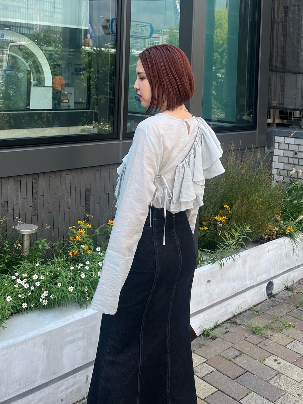 ブラック系のデニムスカート、ブルー系のシャツ/ブラウス、レッド系のショルダーバッグを着用したレディースの秋コーディネートの5枚目の写真