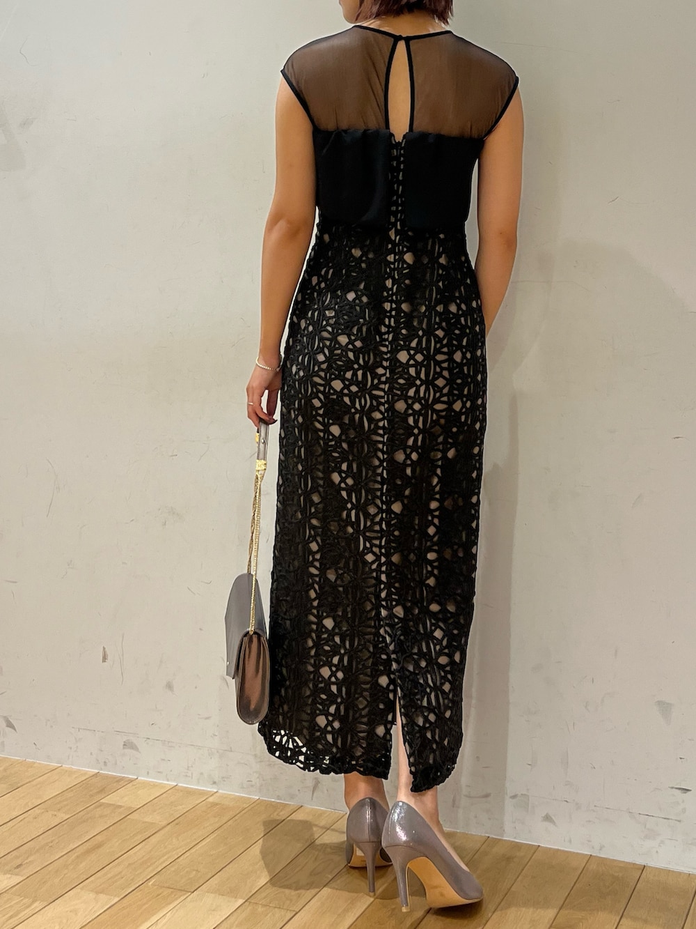 ブラック系のドレス、シルバー系のハンドバッグ、シルバー系のパンプスを着用したレディースの秋コーディネートの3枚目の写真