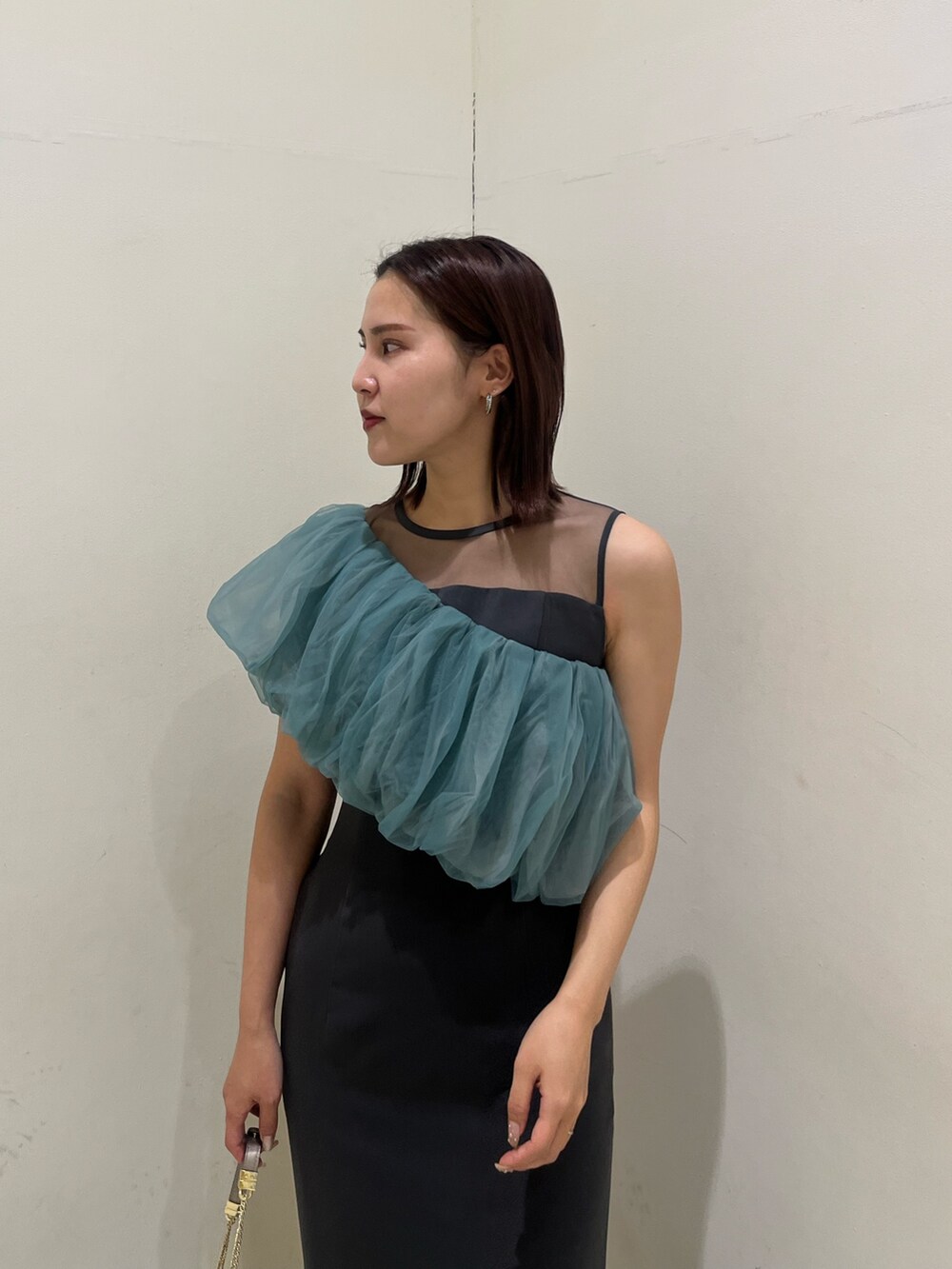 シルバー系のクラッチバッグ、シルバー系のパンプス、グレー系のドレスを着用したレディースの冬コーディネートの6枚目の写真