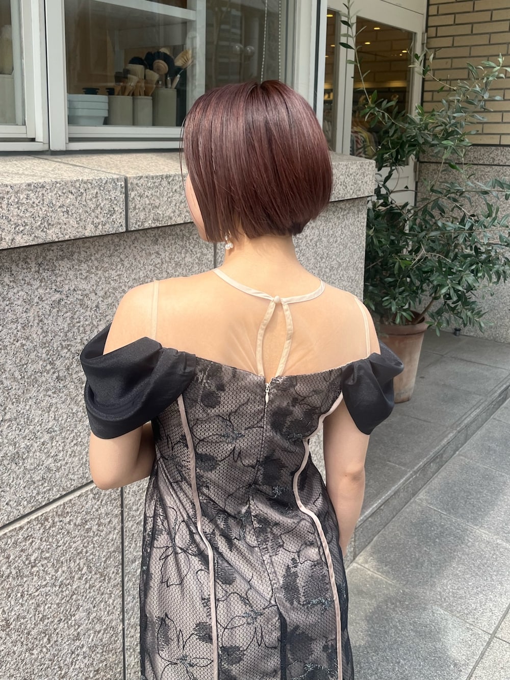 ベージュ系のパンプス、ベージュ系のハンドバッグ、ブラック系のドレスを着用したレディースの春コーディネートの4枚目の写真