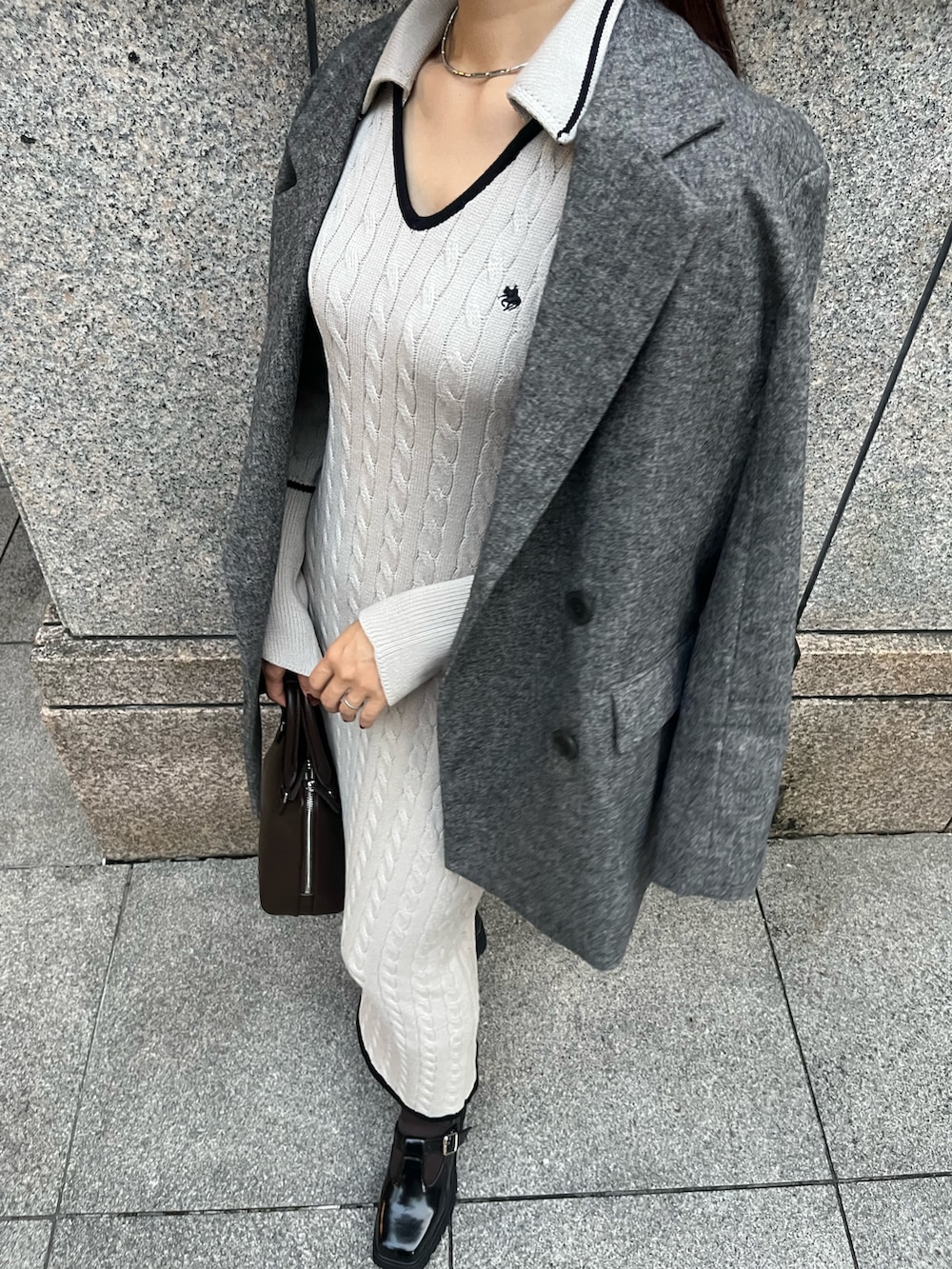 ブラウン系のボストンバッグ、ブラック系のローファー、ベージュ系のワンピースを着用したレディースの秋コーディネートの5枚目の写真