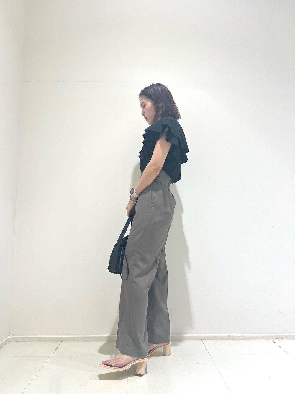 ベージュ系のスラックス、ブラック系のシャツ/ブラウスを着用したレディースの夏コーディネートの4枚目の写真