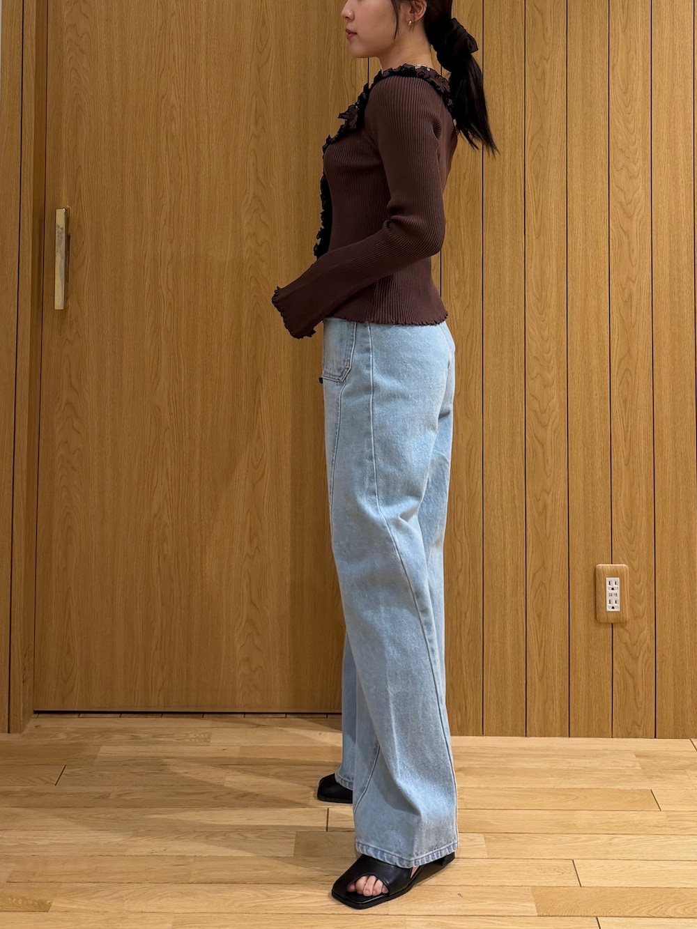 ブラウン系のニット/セーター、ブルー系のデニムパンツ、ブラック系のサンダルを着用したレディースの春コーディネートの2枚目の写真