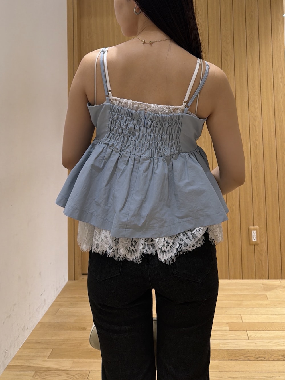 ブラック系のデニムパンツ、ホワイト系のハンドバッグ、ブルー系のキャミソールを着用したレディースの夏コーディネートの6枚目の写真