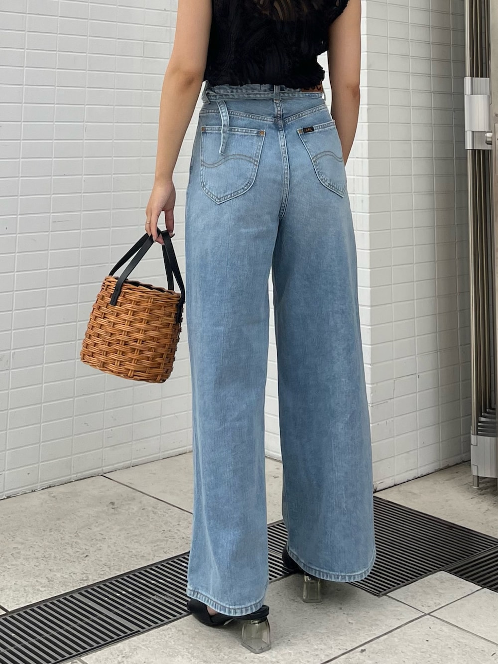 ブラウン系のハンドバッグ、ブラック系のサンダル、ブラック系のシャツ/ブラウスを着用したレディースの夏コーディネートの4枚目の写真