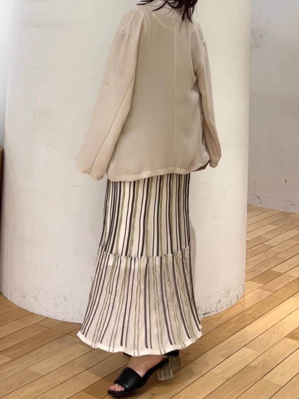 ブラウン系のハンドバッグ、ホワイト系のワンピース、ベージュ系のテーラードジャケットを着用したレディースの春コーディネートの2枚目の写真