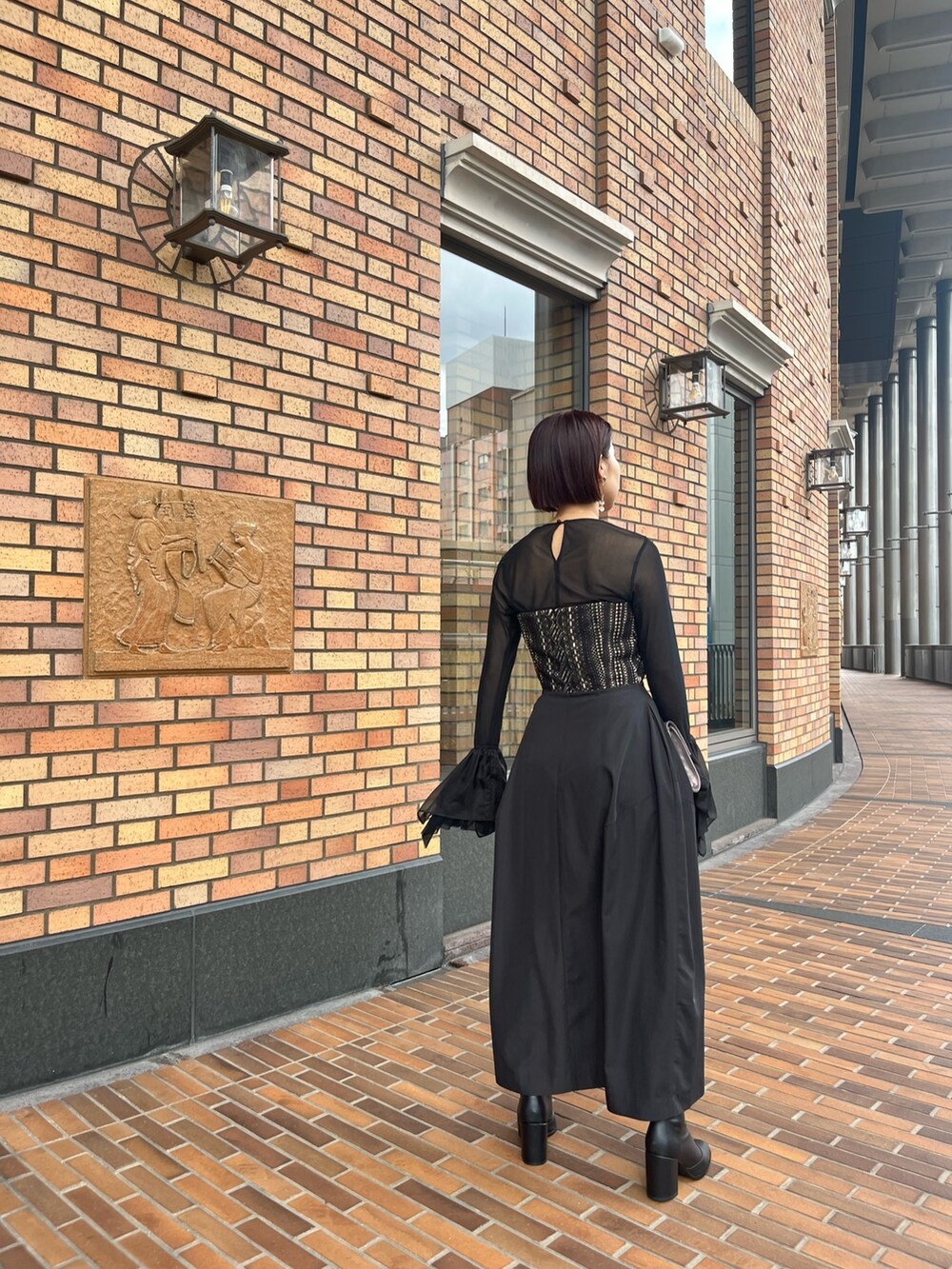 ブラック系のTシャツ/カットソー、ブラック系のドレス、シルバー系のハンドバッグを着用したレディースの秋コーディネートの2枚目の写真