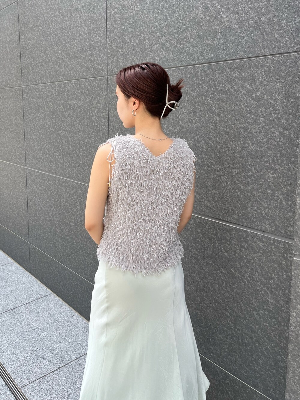 グレー系のTシャツ/カットソー、グリーン系のスカート、ホワイト系のサンダルを着用したレディースの夏コーディネートの6枚目の写真