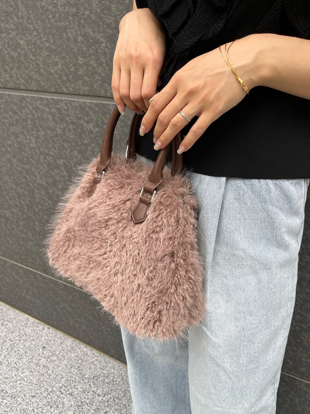 ブラック系のニット/セーター、ブルー系のデニムパンツ、ベージュ系のボストンバッグを着用したレディースの夏コーディネートの8枚目の写真