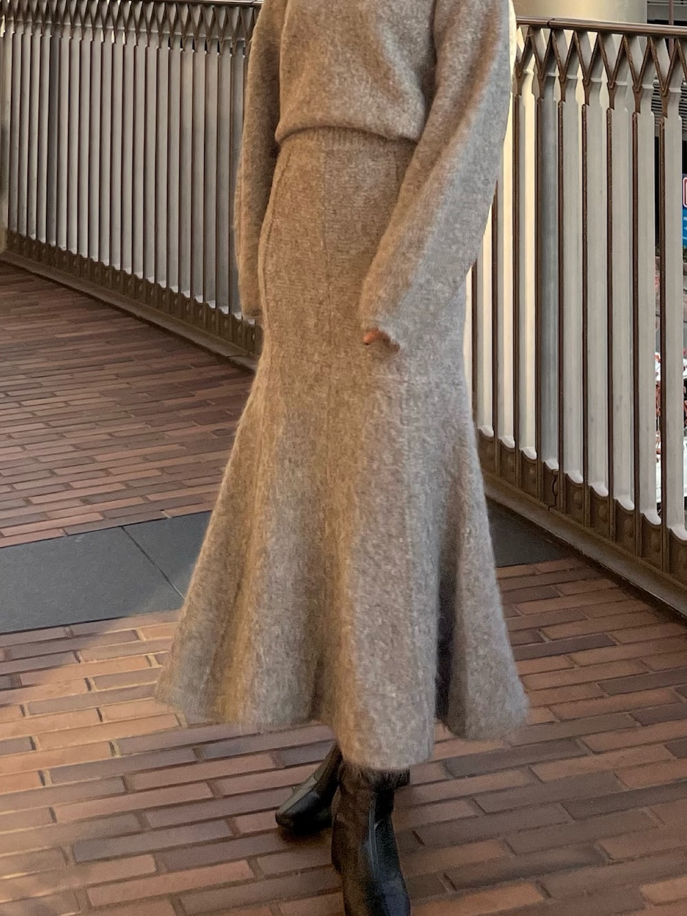 グレー系のスカート、グレー系のニット/セーターを着用したレディースの秋コーディネートの4枚目の写真