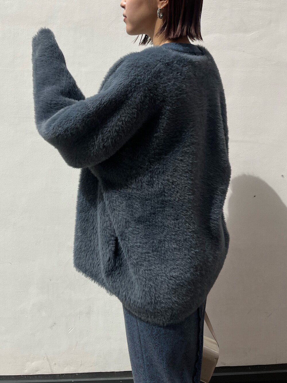 ブラック系のブーツ、ホワイト系のショルダーバッグ、ブルー系のワンピースを着用したレディースの秋コーディネートの5枚目の写真