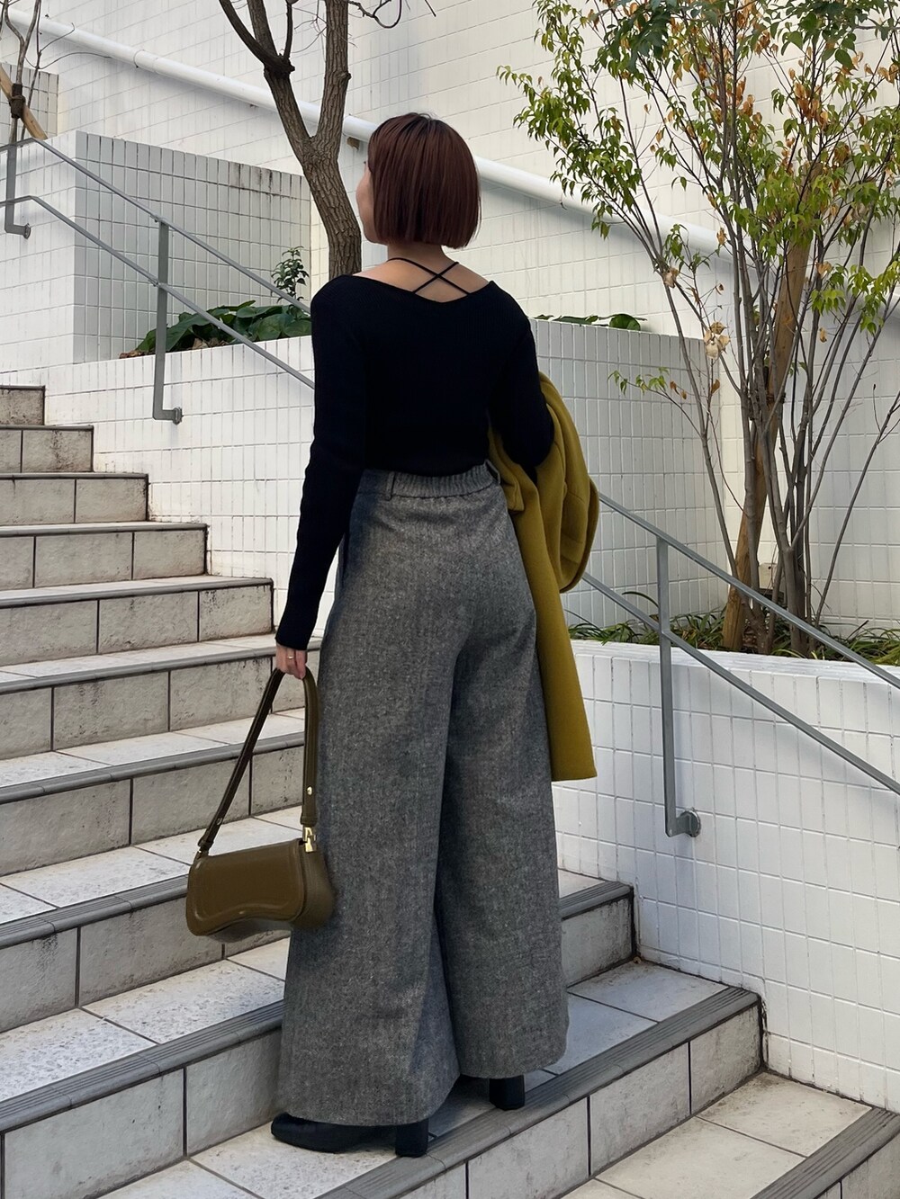 グリーン系のチェスターコート、ブラック系のその他パンツ、ブラック系のニット/セーターを着用したレディースの冬コーディネートの5枚目の写真