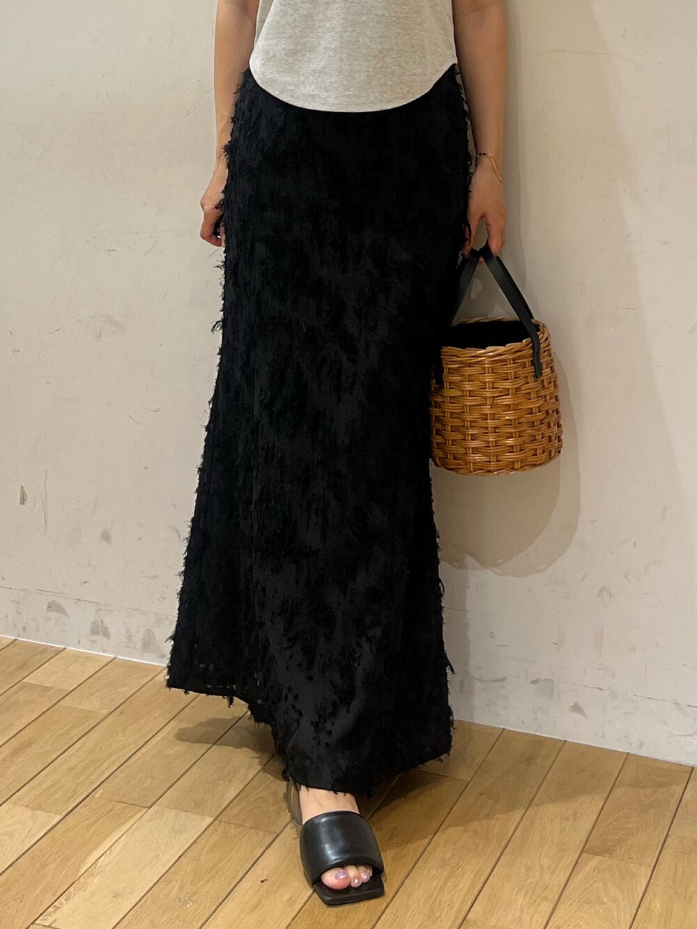 ブラック系のスカート、グレー系のTシャツ/カットソー、ブラウン系のハンドバッグを着用したレディースの夏コーディネートの6枚目の写真