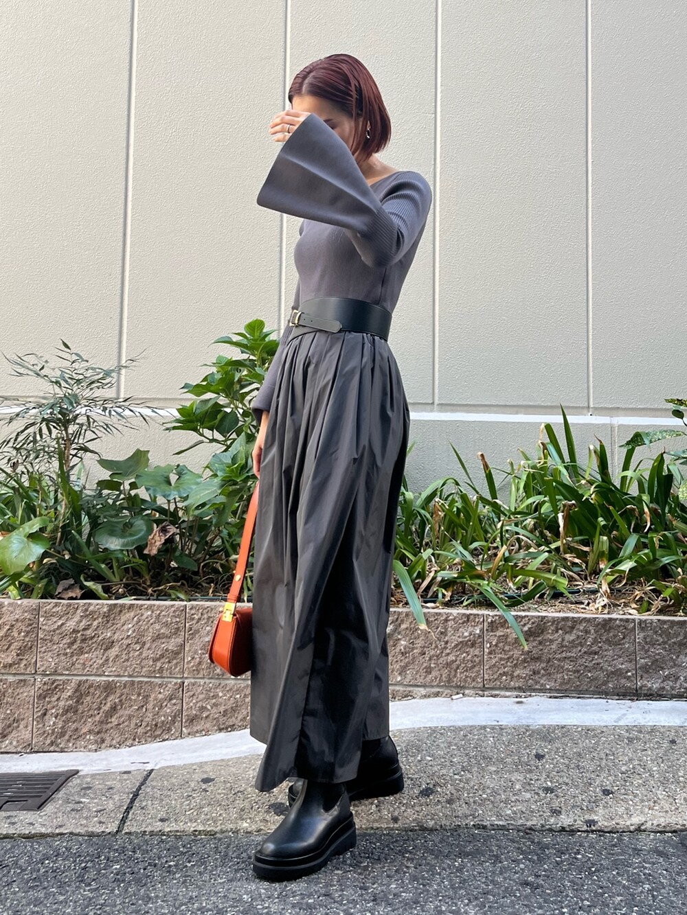 グレー系のワンピース、オレンジ系のショルダーバッグ、グレー系のその他アウターを着用したレディースの秋コーディネートの5枚目の写真