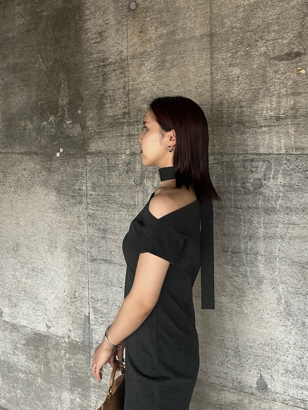 グレー系のワンピース、ブラウン系のハンドバッグ、ブラック系のサンダルを着用したレディースの夏コーディネートの5枚目の写真