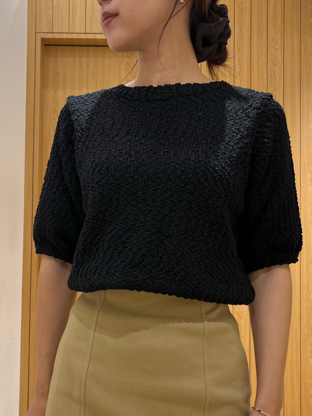 ブラック系のブーツ、ベージュ系のスカート、ブラウン系のボストンバッグを着用したレディースの秋コーディネートの5枚目の写真