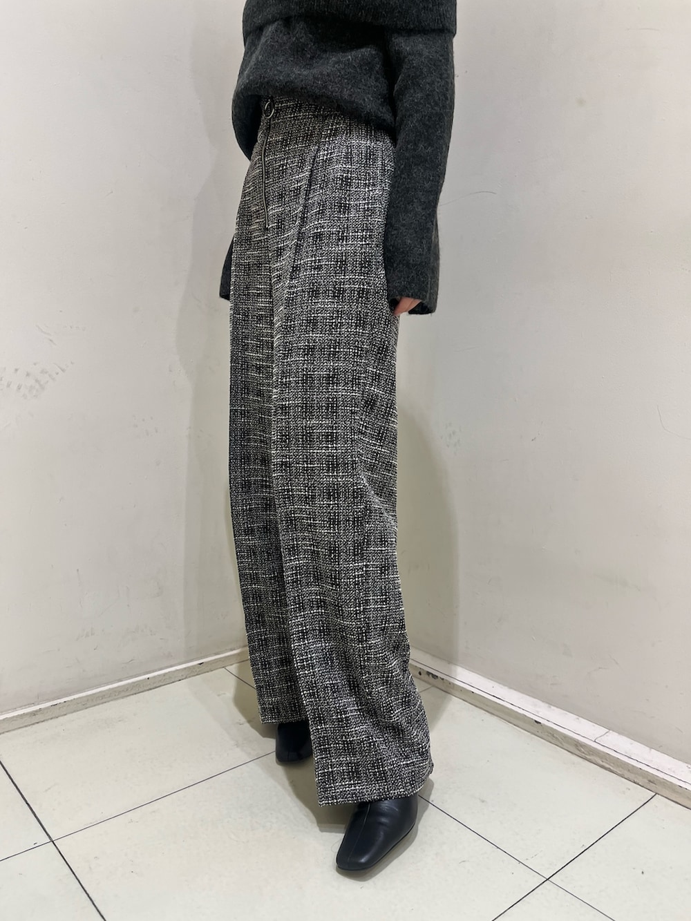 グレー系のニット/セーター、ブラック系のその他パンツ、ブラック系のブーツを着用したレディースの冬コーディネートの6枚目の写真