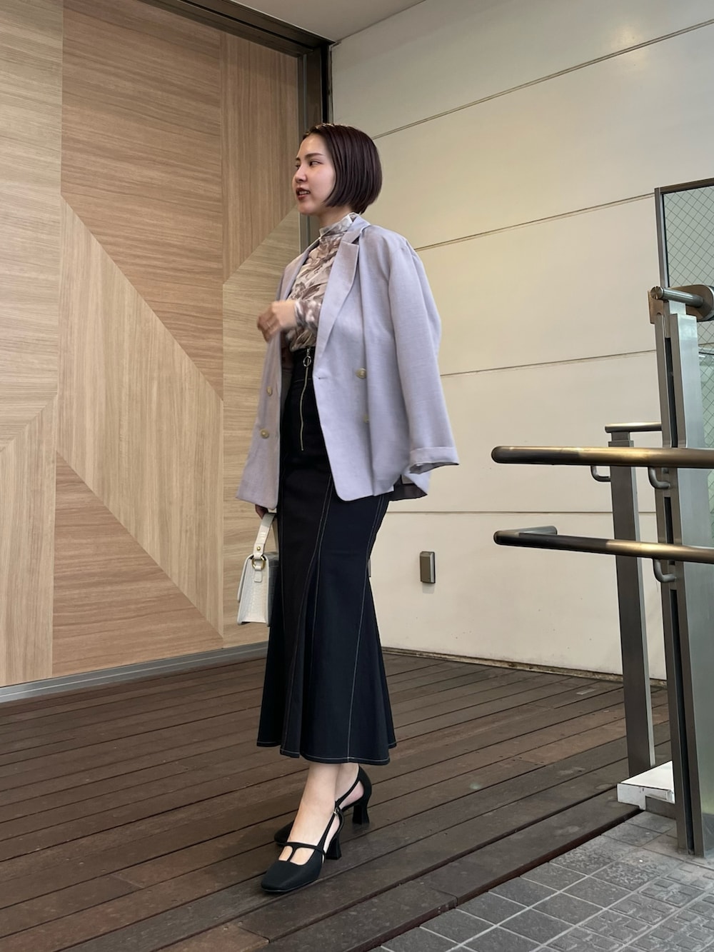 ブラック系のスカート、ブラック系のパンプス、イエロー系のTシャツ/カットソーを着用したレディースの春コーディネートの6枚目の写真