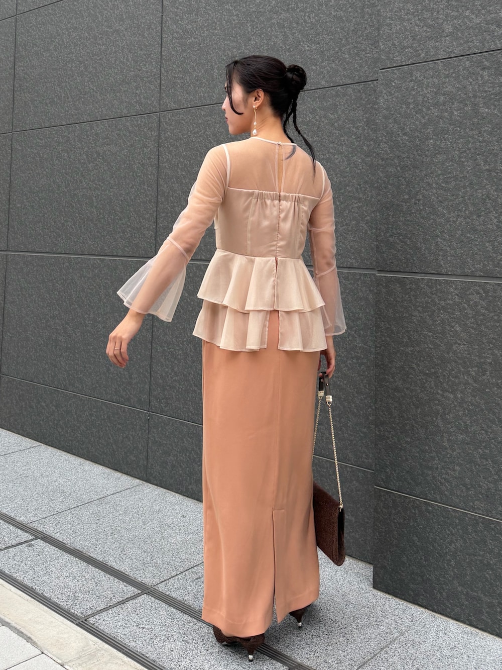 その他のクラッチバッグ、その他のパンプス、ピンク系のドレスを着用したレディースの冬コーディネートの3枚目の写真