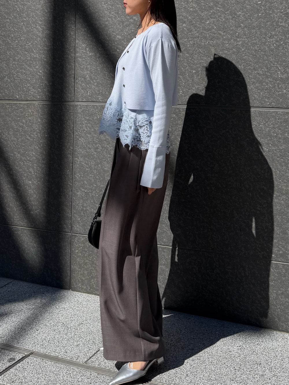 ブルー系のトレンチコート、グレー系のその他パンツ、ブラック系のハンドバッグを着用したレディースの冬コーディネートの7枚目の写真