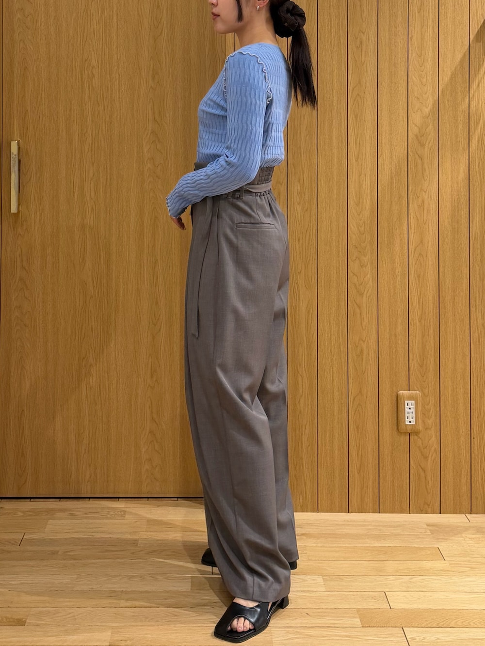 グレー系のその他パンツ、ブルー系のニット/セーター、ブラック系のサンダルを着用したレディースの春コーディネートの2枚目の写真