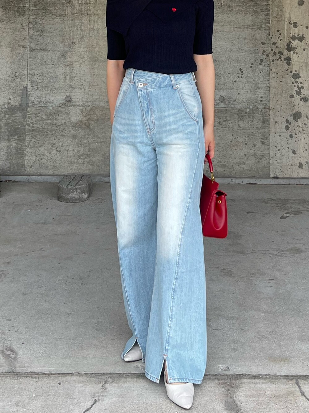 ブルー系のデニムパンツ、ブルー系のニット/セーター、レッド系のハンドバッグを着用したレディースの春コーディネートの5枚目の写真