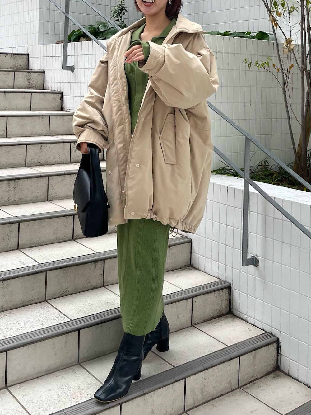 ブラック系のブーツ、ブラック系のハンドバッグ、グリーン系のワンピースを着用したレディースの冬コーディネートの7枚目の写真